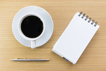 Coffee and notepad on wood table