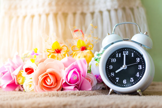 White clock with flowers on a table in muted vintage retro style