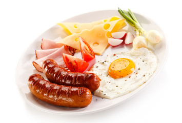 Breakfast - fried egg and sausages, cheese, ham and vegetables 