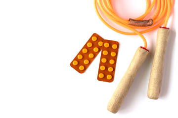 Orange jump rope with blisters of pills on white background. Hea