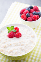 Oatmeal porridge in bowl with berries raspberries and blackberri