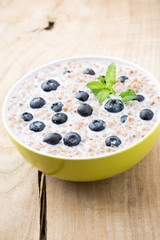 Buckwheat porridge in a bowl with mint leaves and blueberries.