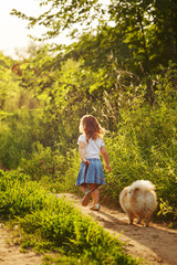 Little girl walking with a dog