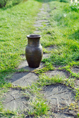 Obraz premium Piece of pottery pot from clay on the background of the garden paths.
