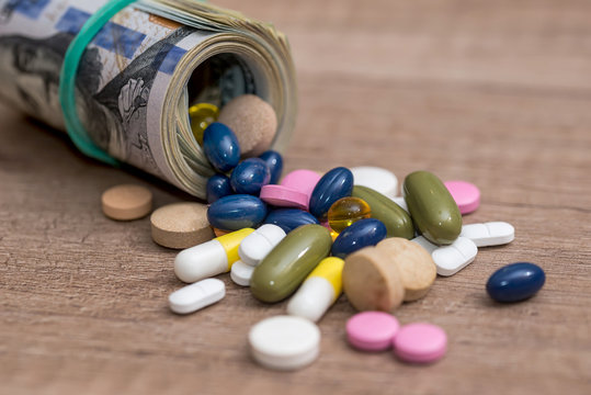 pills and dollar on wooden table
