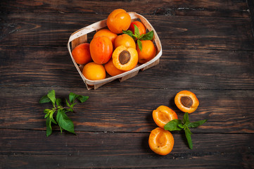 apricots in a basket on dark wood background