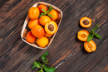 apricots in a basket on dark wood background