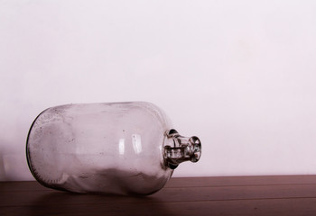 Clear glass demijohn against a light background
