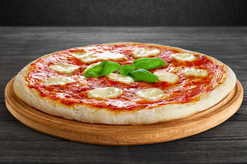 Pizza Margherita on dark wooden background