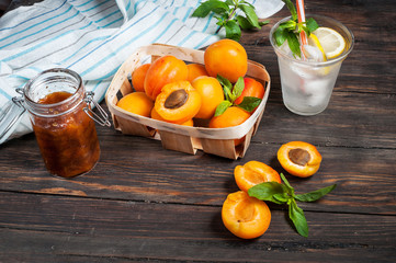 Cold fresh lemonade and apricots on wood background