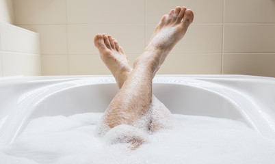 Men's feet in a bathtub, selective focus on toes