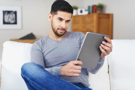 mann liest zuhause am tablet