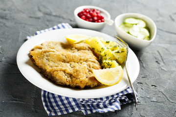 Classic schnitzel with lemon, potato, cucumber salad and berries