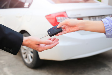 Business hand giving a key for buyer or rental car.