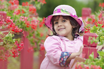 The little girl close in a pink hat and a raincoat. green backgr