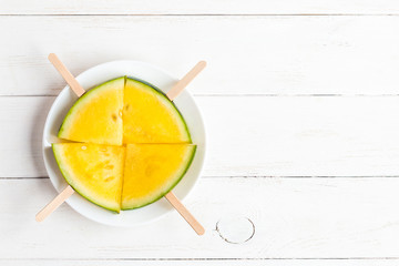 popsicle yellow watermelon on wooden white background, top view, flat lay - Powered by Adobe