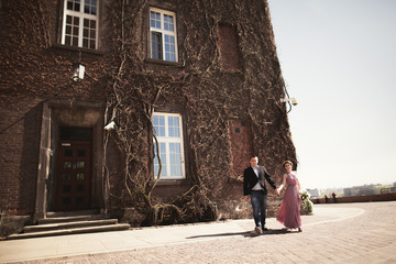 Young wedding couple in love story, bride and groom posing near building on the background. Krakow
