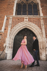 Naklejka premium Elegant beautiful wedding couple posing near a church. Krakow