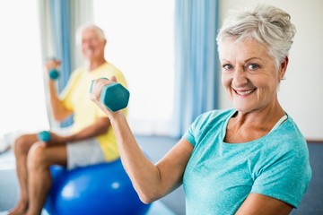 Seniors using exercise ball and weights