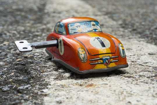 Clockwork toy car on asphalt background