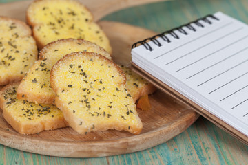 garlic bread and paper note on wood table