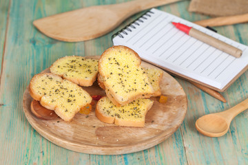 garlic bread and paper note on wood table