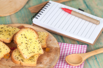 garlic bread and paper note on wood table