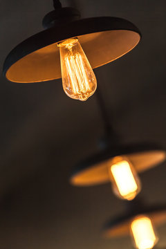 Retro tungsten lamps glowing over dark ceiling