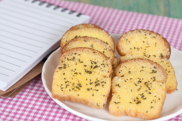 garlic bread and paper note on wood table