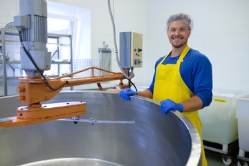 Confidant cheesemaker standing in his workshop.