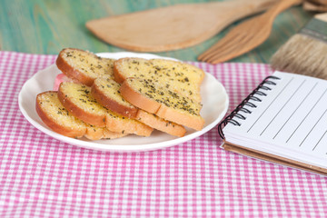 garlic bread and paper note on wood table