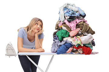 Sad woman leaning on an ironing board