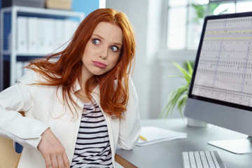 frau im büro schaut genervt zur seite