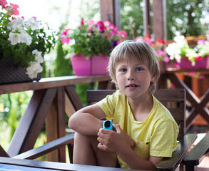 Cute boy using smart watch  on a terrace   © Tatiana Murr