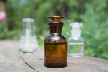 Liquid in chemical ware on a background of plants, fertilizers or pesticides in the garden.