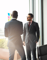 Serious young businessman talking to a colleague