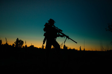 Silhouette of military soldier or officer with weapons at night.