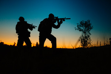 Fototapeta na wymiar Silhouette of military soldiers with weapons at night. military concept.