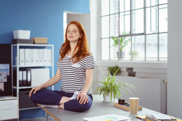 frau praktiziert yoga im büro