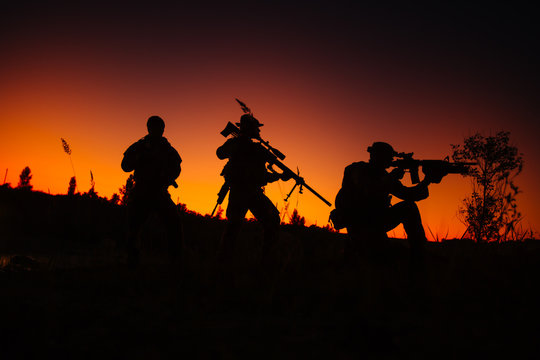 Silhouette of military soldiers with weapons at night. military concept.