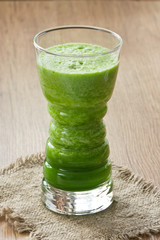 Green spinach smoothie / Fresh spinach and green apple smoothie in glass on wooden background
