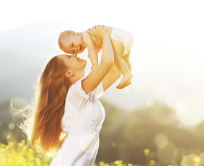 happy family outdoors. mother throws baby up, laughing and playi