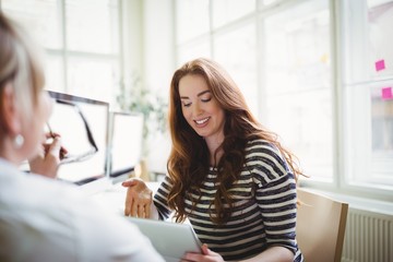 Obraz premium Businesswoman using laptop while discussing