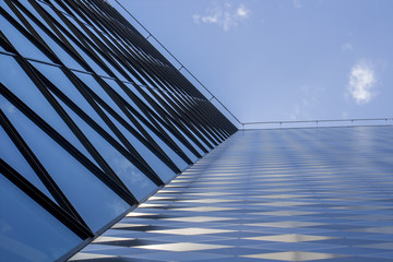 Fototapeta premium Modern office building made from glass and steel. Low angle view. Sky background.