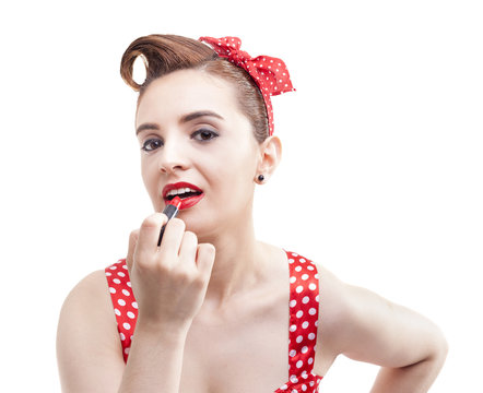 Pin-up girl applying red lipstick on the lips, isolated over whi