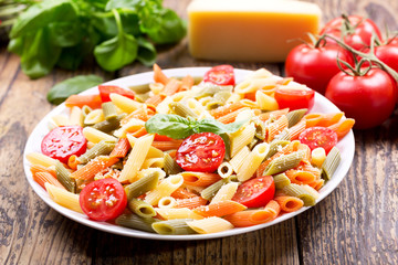 plate of pasta with tomato and green basil