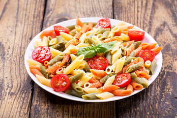 plate of pasta with tomato and green basil