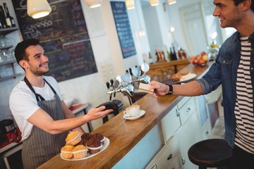 Happy customer and waiter at coffee shop