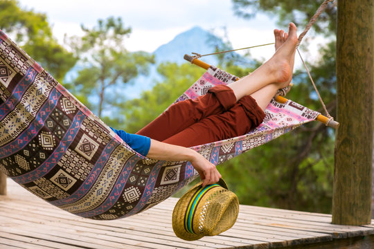 Person relaxing in Hummock holding Travel Hat