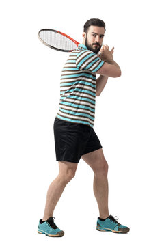 Tennis player waiting to hit ball holding racket with both hands in backhand pose. Full body length portrait isolated over white studio background.